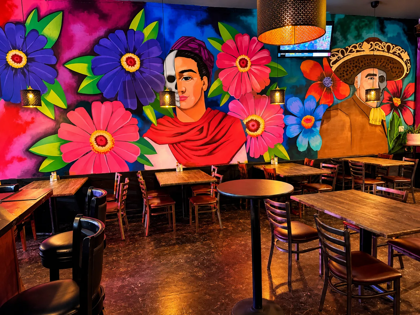 Mural de flores con un retrato estilo Día de Muertos sobre el comedor